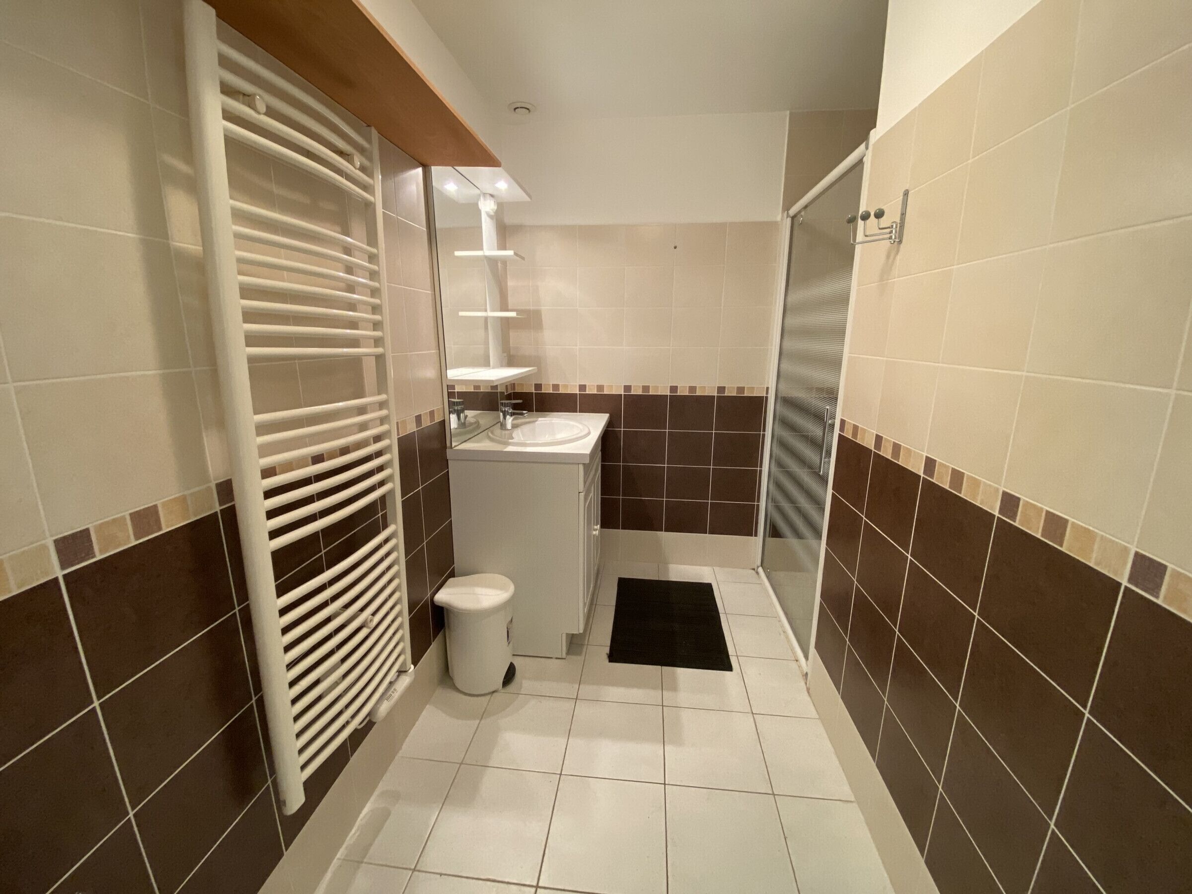A compact bathroom with a toilet, sink, and shower.