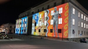 A building with colorful murals on its facade, featuring abstract and figurative art.