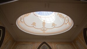 Un plafond agrémenté d’une lucarne et de moulures décoratives.