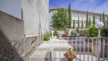 Una scala con ringhiera metallica conduce a un edificio con facciata bianca e numerose finestre.