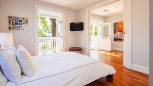 Un dormitorio con una cama grande, televisión y vistas al exterior.