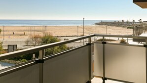 Ein Balkon mit Blick auf Strand und Meer.