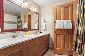 A bathroom with a wooden door, a large mirror, and a sink with a towel rack. - 1 Minute Walk to the Super Bee Chair! Enjoy the Best of Copper from this Beautif (Frisco)