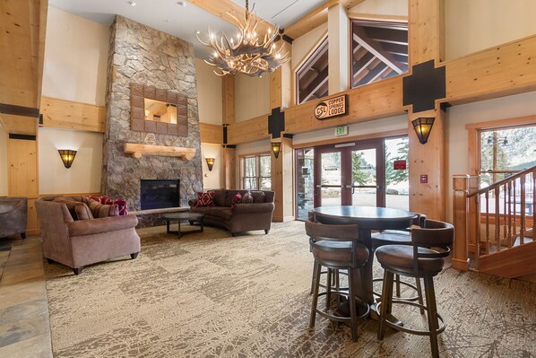 A spacious lobby with a stone fireplace, a high ceiling, and a view of the outdoors. - 1 Minute Walk to the Super Bee Chair! Enjoy the Best of Copper from this Beautif (Frisco)