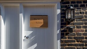 A white door with a wooden sign that reads "The Monk's Retreat." - Cute and cosy home in the centre of Canterbury. - Pass the Keys (Canterbury)