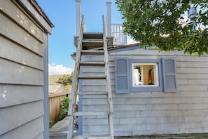 A house with a wooden ladder leading to a window with shutters. - Bodega Bay• Beach Retreat • Easy Walk to Sand-Surf-Fun–Fisherman’s Cottage (Bodega Bay)