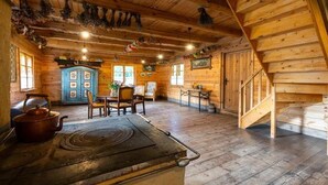 A rustic wooden interior with a dining area, a kitchen stove, and a staircase. - Large, atmospheric cottage in the countryside (Belczna)