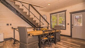 A dining area with a wooden table and chairs, a staircase, and a clock on the wall. - Million $ Views, Game RM, Pvt Pool, Lux (Sevierville)
