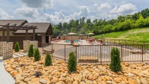 A pool area with a pergola, lounge chairs, and a fenced patio. - SAVE! 2 Min to Pkwy! Luxury Apt Best Price (Sevierville)