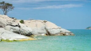 A beach with clear turquoise water, white sandy shore, and rocky outcrops. - Villa SAWASDEE (HUA HIN)