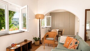 Ein Wohnzimmer mit einer Couch, einem Esstisch und einer Lampe.
