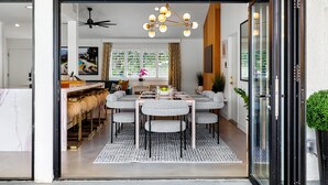 A modern dining area with a table and chairs, a ceiling fan, and a decorative light fixture.