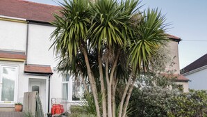 A house with a white exterior, a red-tiled roof, and a wooden fence with a 'HILLSIDE' sign. - Dulas (Llandudno Junction)