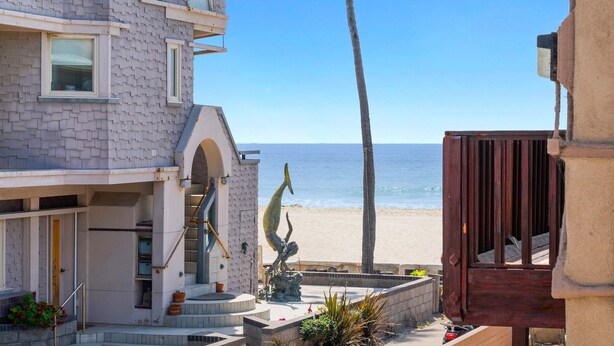 A beachfront hotel with a stone facade, a palm tree, and a beach view. - Pacific Surf  in Mission Beach | Steps to the Sand (San Diego)