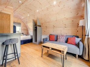 A cozy, wooden interior with a kitchenette, a sofa, and a dining table. - 1 bedroom accommodation in Scarborough (Scarborough)
