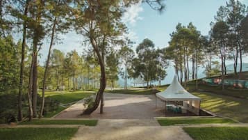 Campo de golf con una carpa, árboles y cielo despejado.