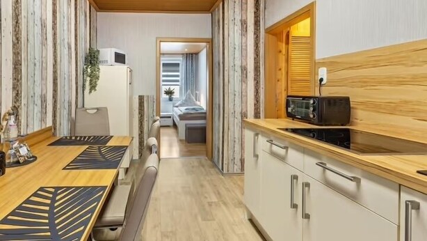 Eine kleine Küche mit einer Holzausziehtafel, einer Mikrowelle und einem Spülbecken.