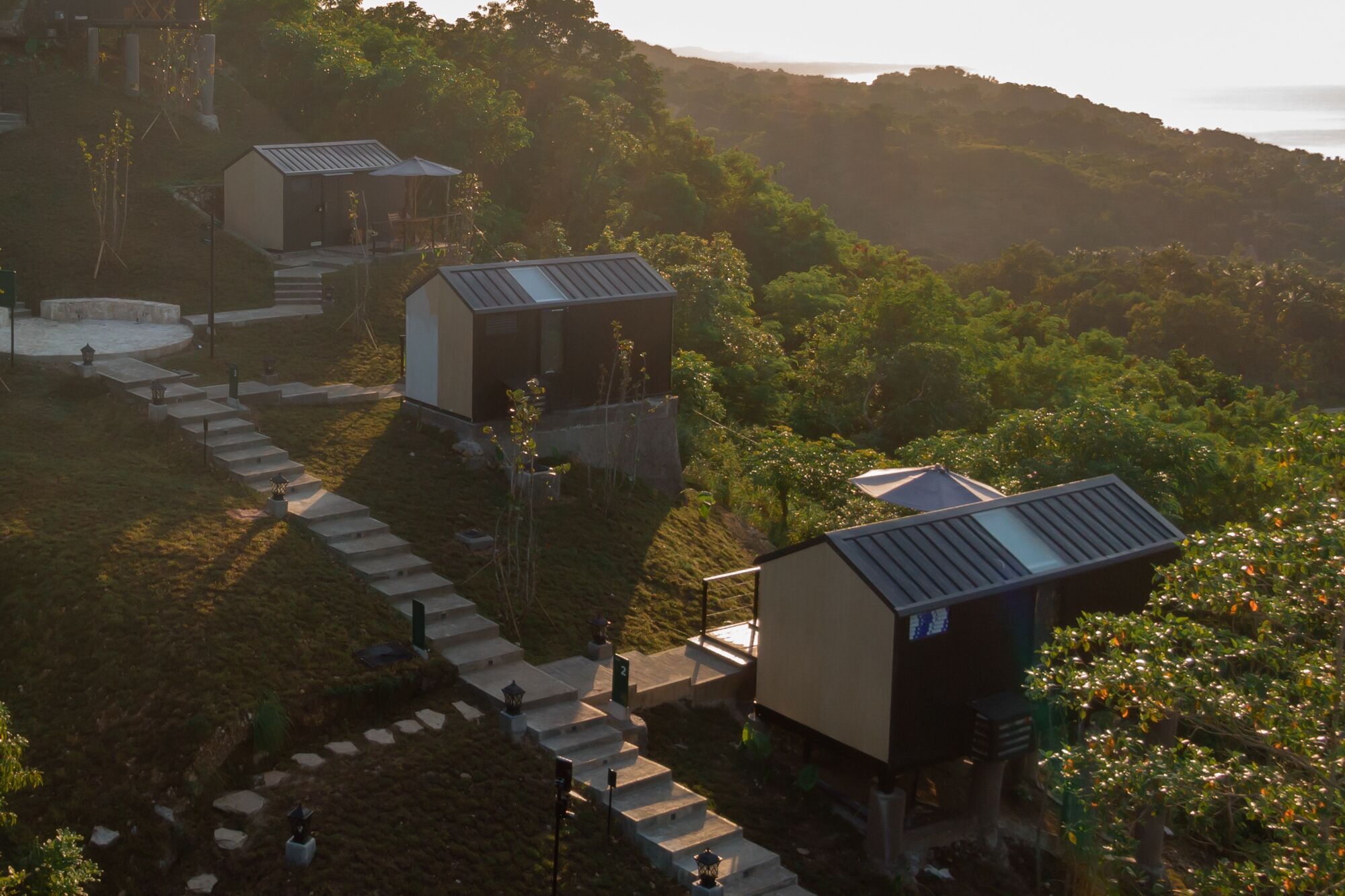 Un barrio residencial con casas modernas, un sendero de piedra y abundante vegetación.