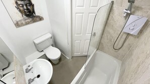 Une salle de bain avec des toilettes, un lavabo et une baignoire.
