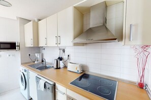 A kitchen with a microwave, toaster, sink, and stove. - Beautiful apartment overlooking the pool- MO2411LT (La Torre Golf Resort)