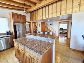 Enjoy cooking in this well-equipped kitchen with a granite island, ample counter space, and stainless steel appliances.