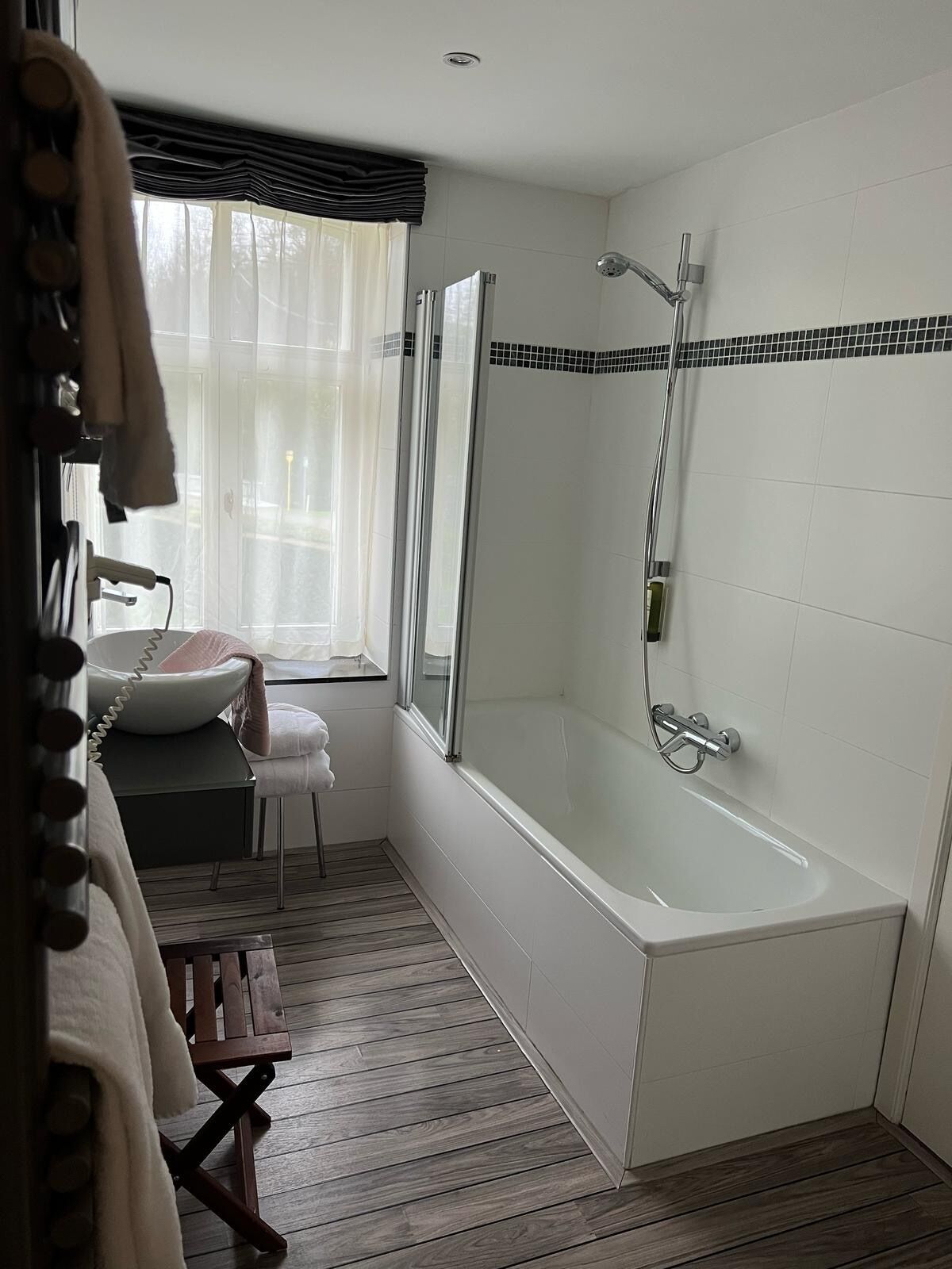 Un baño moderno con una bañera independiente, un tocador con lavabo y un espejo.
