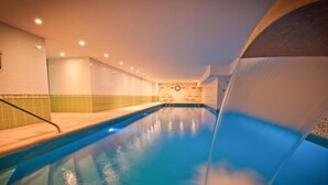An indoor swimming pool with clear water, tiled walls, and a few lounge chairs. - Moulin de Daverdisse (Daverdisse)