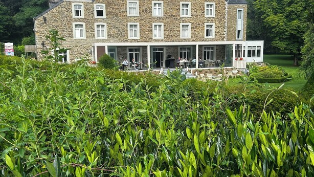 A stone building with multiple windows and a covered outdoor seating area. - Moulin de Daverdisse (Daverdisse)