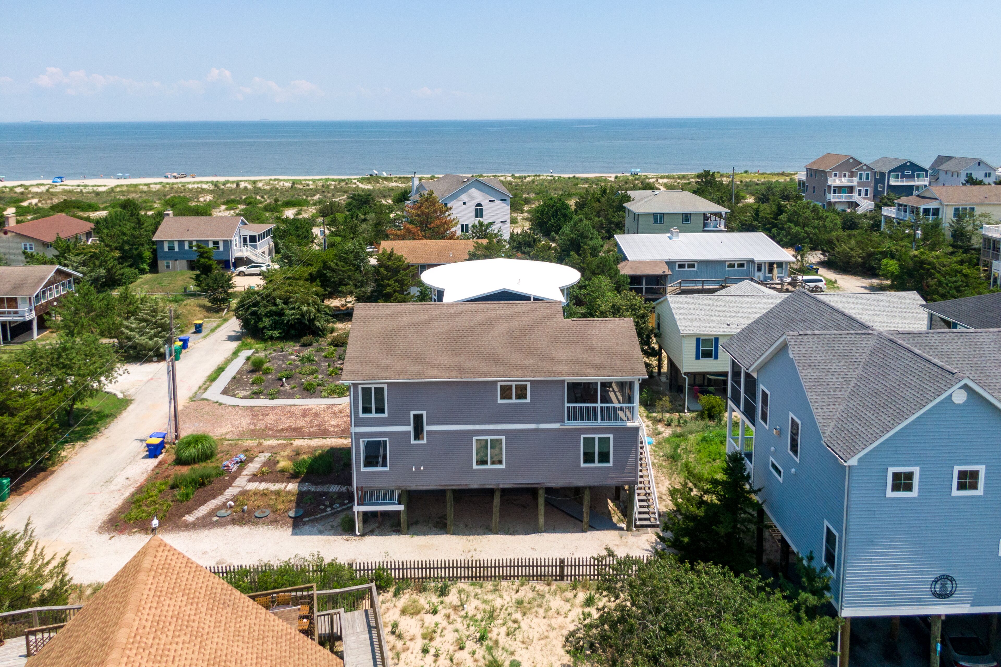 A coastal residential area with houses, a beach, and a large white satellite dish.