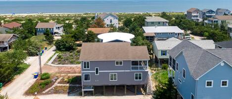 A coastal residential area with houses, a beach, and a large white satellite dish.