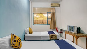 A hotel room with two beds, a TV on a wooden table, and a window with curtains. - Spot ON 90964 Hotel Margadana (Tegal)