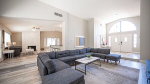 A spacious living room with a sectional sofa, a coffee table, and a fireplace. - Stylish 4 Bed, 3 Bath in Henderson/Green Valley! (Henderson)
