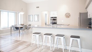 A modern kitchen with a large island, bar stools, and a dining area with a table and chairs. - Stylish 4 Bed, 3 Bath in Henderson/Green Valley! (Henderson)