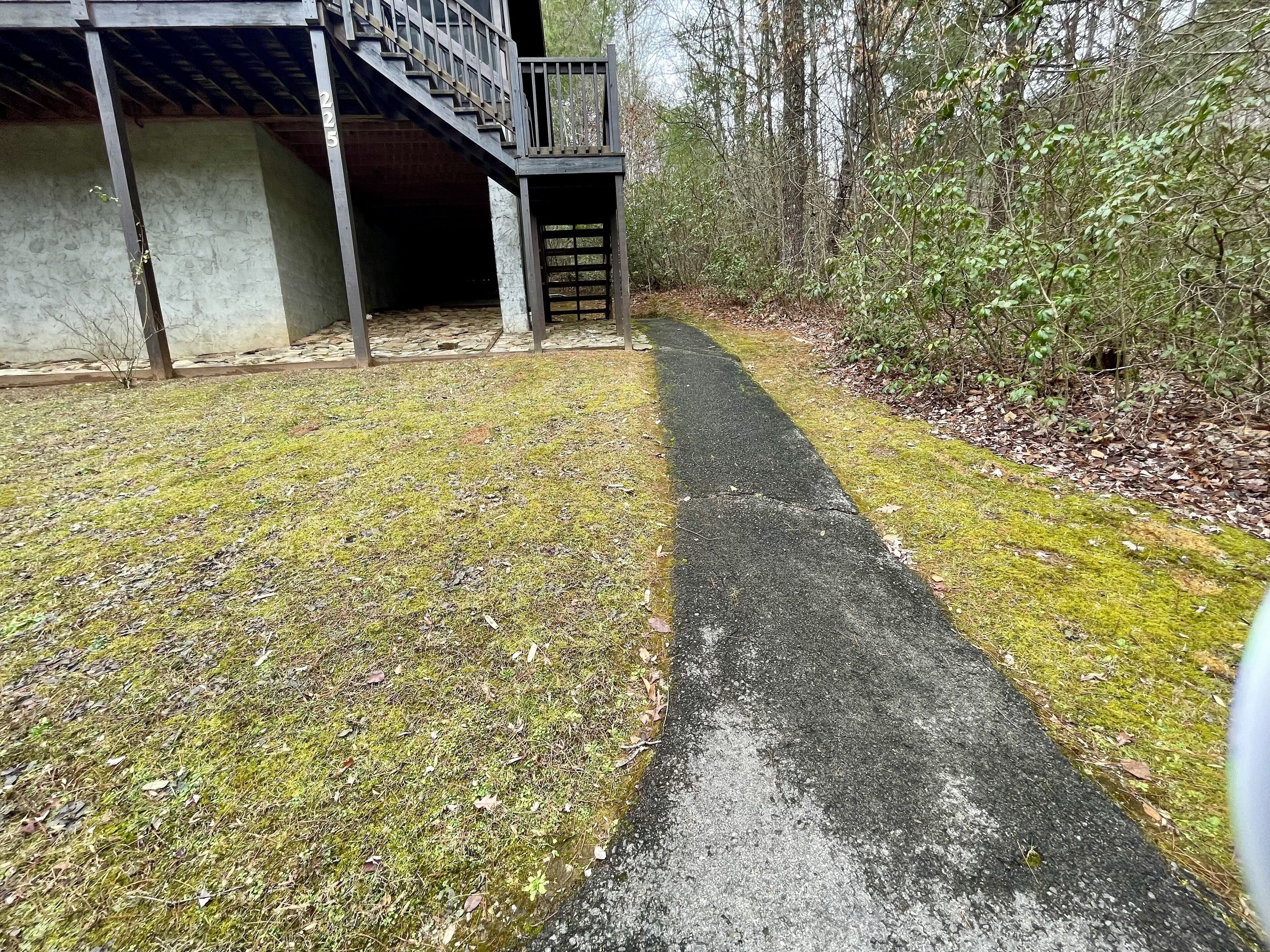 A pathway leading to a building with a staircase and a gated entrance.