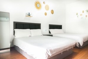 A hotel room with two beds, a nightstand, a wall-mounted shelf, and a mirror.