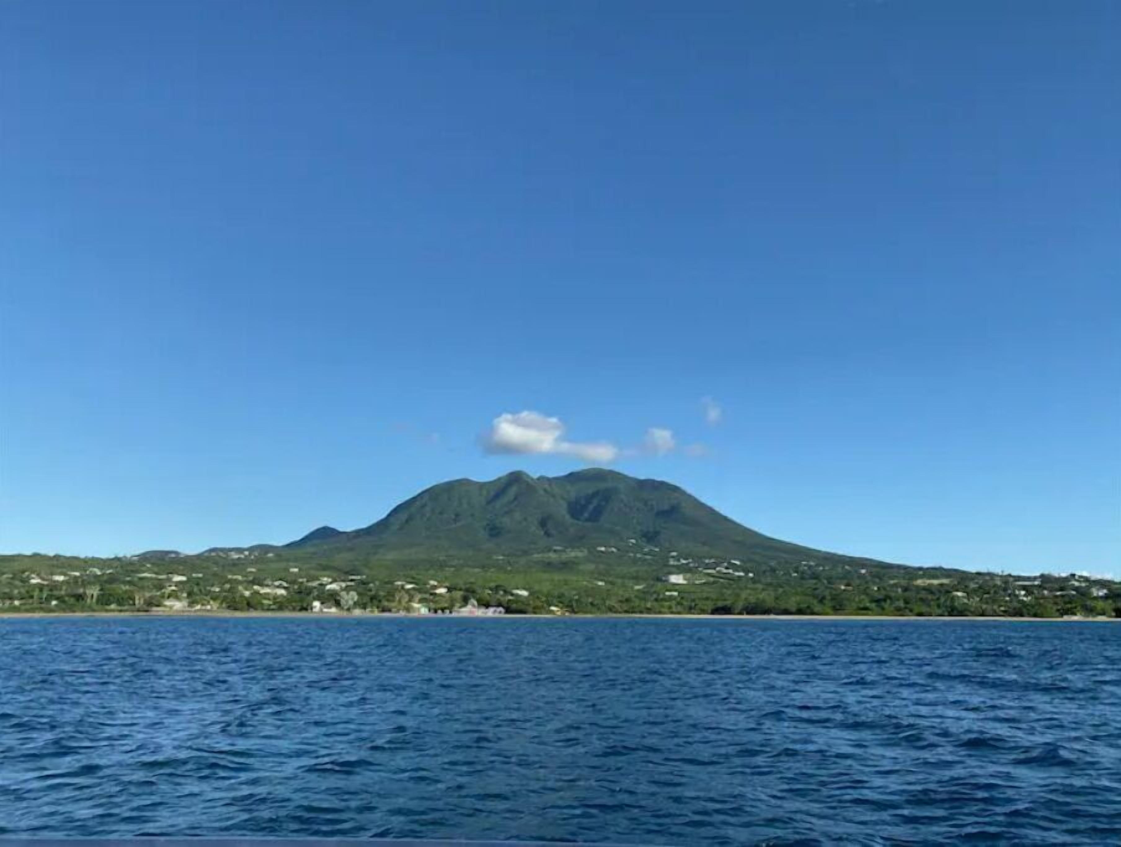 A mountain with a clear sky and calm sea.