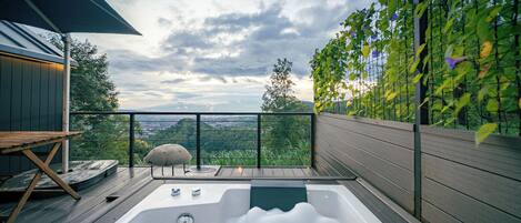 Un bain à remous sur une terrasse offrant une vue sur le paysage.