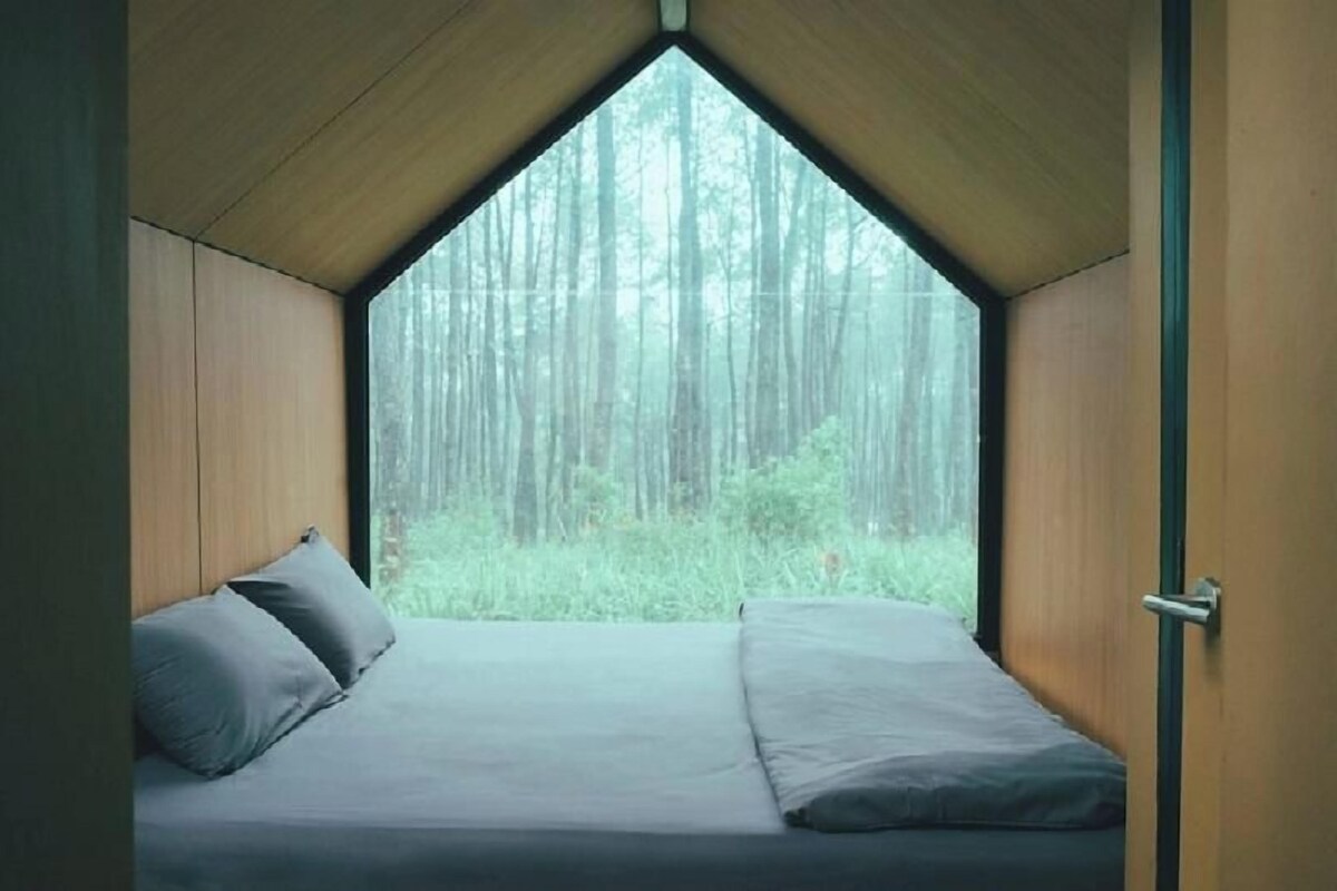 A room with a bed, a window, and a door.