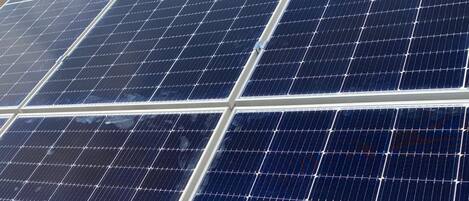 A close-up of solar panels with a clear sky in the background.