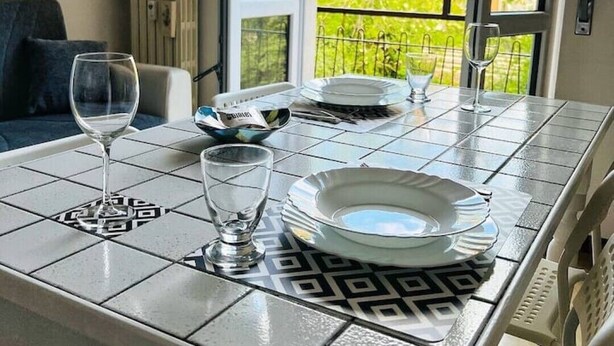 A dining table with plates, glasses, and a bowl set for a meal. - one bedroom apartment with parking, 5 minutes walk from piazzale Arnaldo (Brescia)