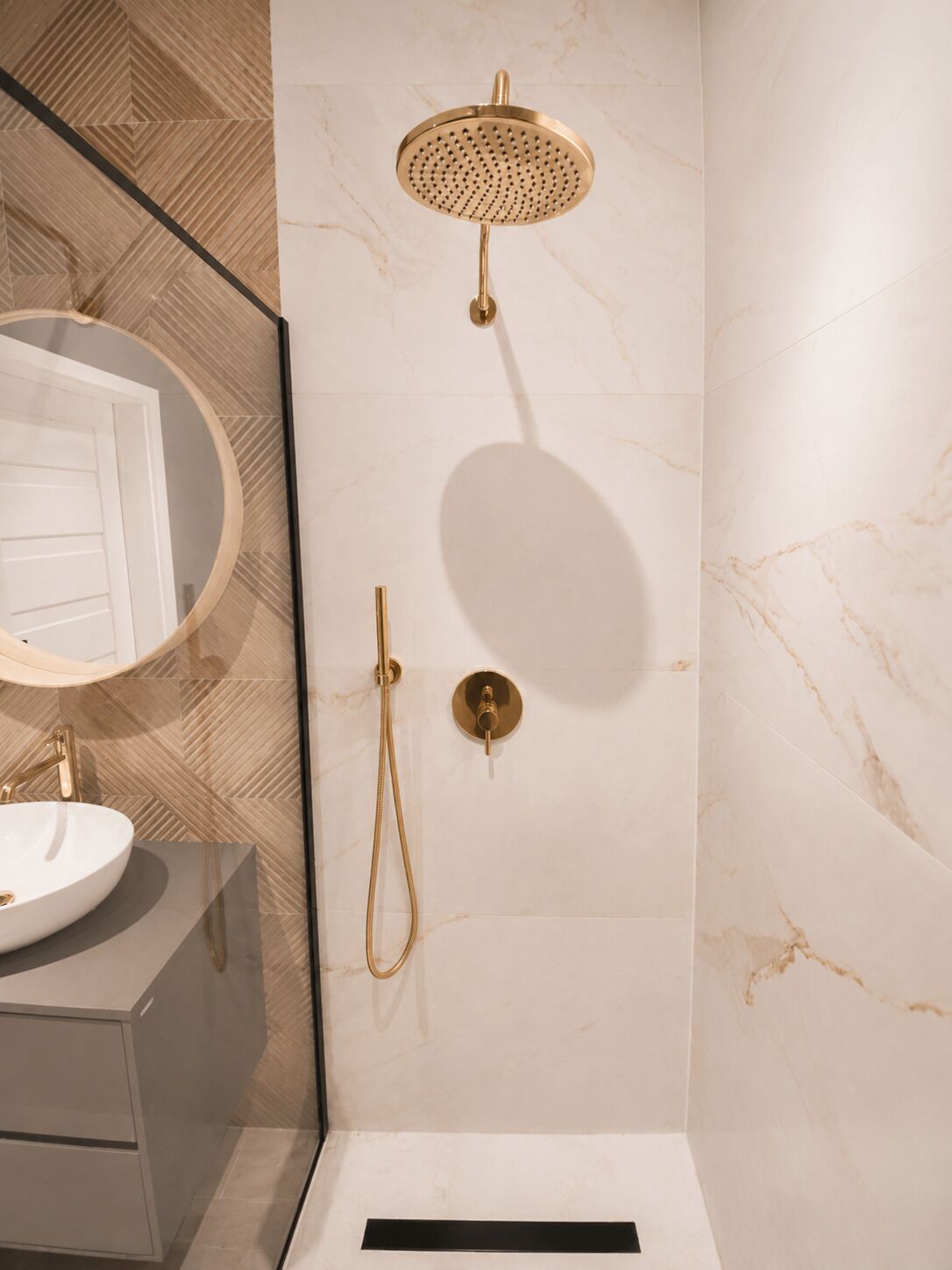 A bathroom with a freestanding bathtub, a showerhead, and a vanity with a mirror.