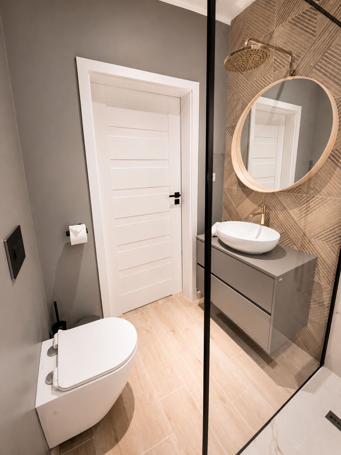 A modern bathroom with a toilet, sink, and shower.