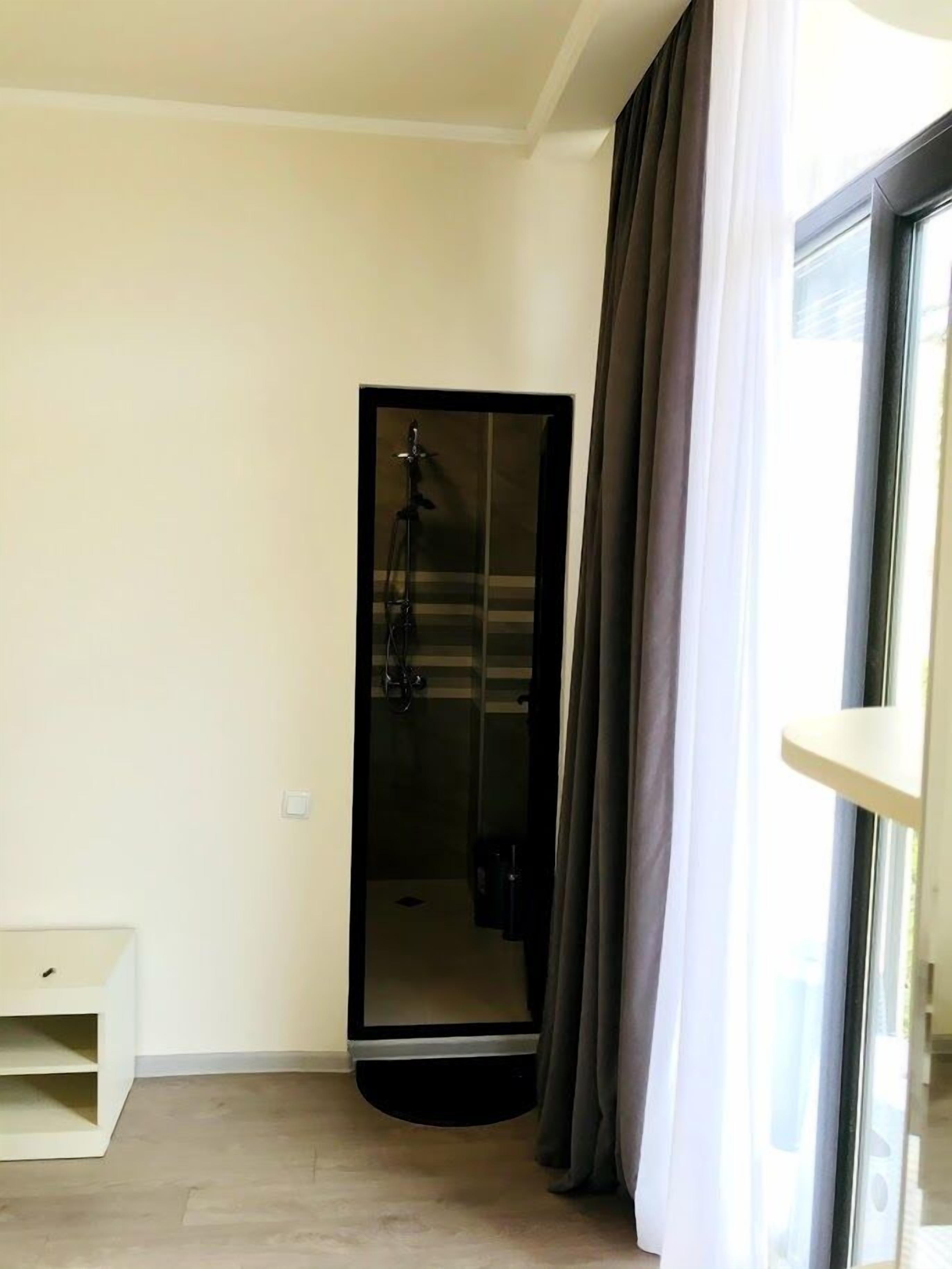 Habitació moderna amb porta corredissa de vidre que dona a una zona de dutxa.