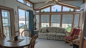 A sunroom with a dining table, chairs, a sofa, and a chair. - Quiet Get away Lot #2 fisherman, family, Pet friendly, boat ramp, dock, Beaches (Port Clinton)