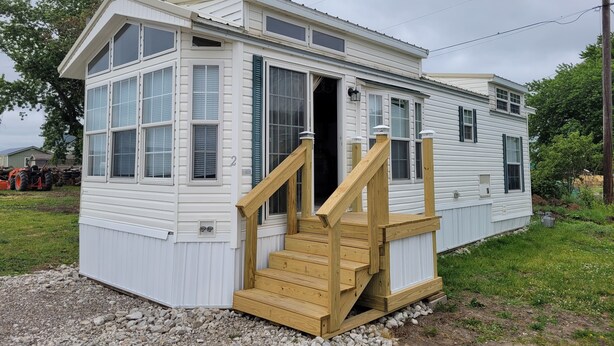 A two-story house with a wooden staircase leading to the front door. - Quiet Get away Lot #2 fisherman, family, Pet friendly, boat ramp, dock, Beaches (Port Clinton)