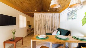 Un comedor con una mesa de madera, sillas tejidas y un banco.