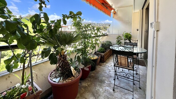 A balcony with potted plants, a table, and a chair. - Bright 31m2, flowered terrace, near Croisette (Cannes)
