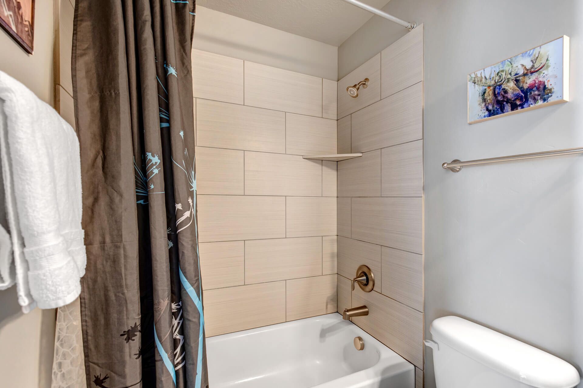 A bathroom with a bathtub, a toilet, and a shower area.