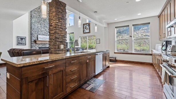 A spacious kitchen with a stone accent wall, wooden cabinets, and a large island.