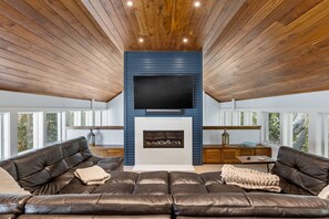 Smart-tv, een open haard, boeken en een kantoor